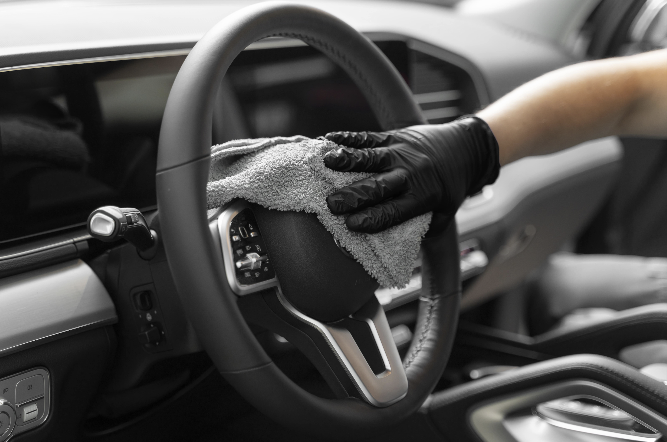 Interior car detailing with deep cleaning of steering wheel, dashboard and trim.